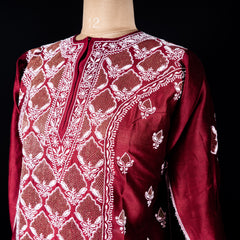 Detailed embroidery on neckline with golden threadwork on red silk fabric