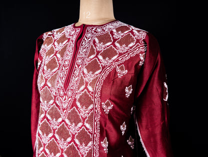 Detailed embroidery on neckline with golden threadwork on red silk fabric